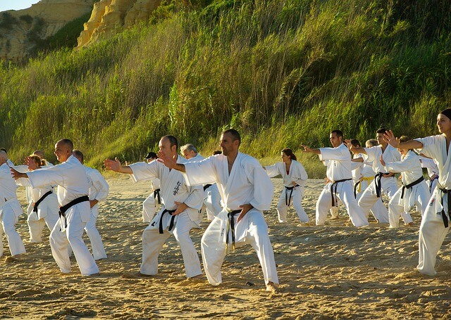 group of people training karate at the beach